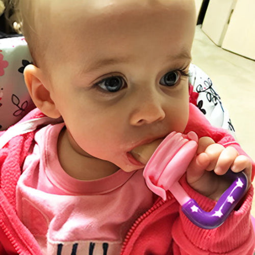 grignoteuse bebe etoile rose dans la bouche de bébé