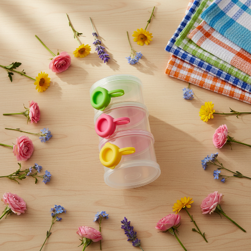 Boite doseuse lait vert avec fleurs et serviettes sur le comptoir de cuisine