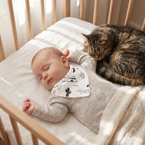 Bavoir bandana au cou du bébé coucher dans son avec son chat