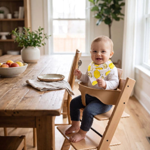 bandana imperméable autour du cou de bébé assis dans sa chaise haute a la table de cuisine