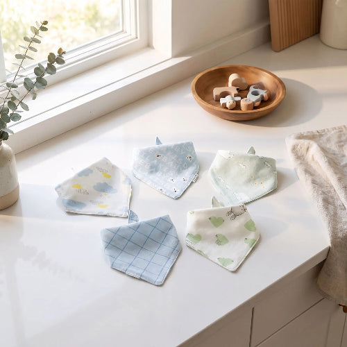 Bavoir bandana bébé bleu sur le comptoir de cuisine près de la fenêtre lumineuse