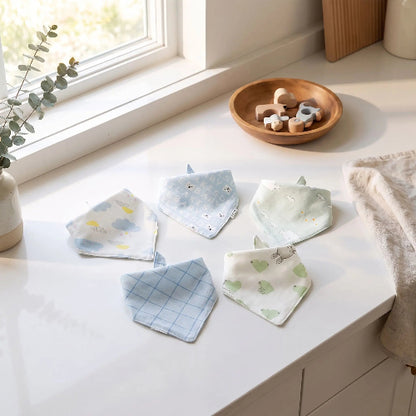 Bavoir bandana bébé bleu sur le comptoir de cuisine près de la fenêtre lumineuse