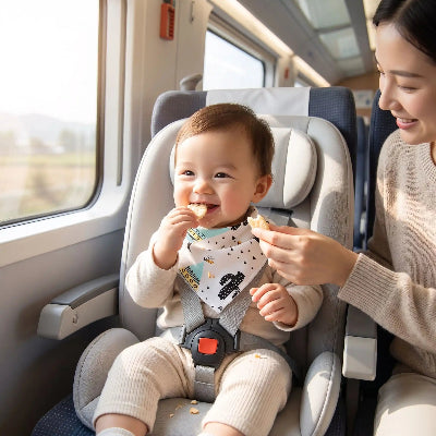 Bavoir bandana bébé assis dans le train avec maman entrain de manger une collation