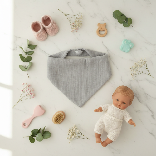 Bavoir bandana bébé gris sur le comptoir de cuisine avec jouets
