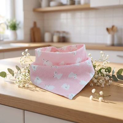 bavoir bandana avec lapin animé sur le bavoit qui est sur le comptoir de cuisine avec des petit fleurs