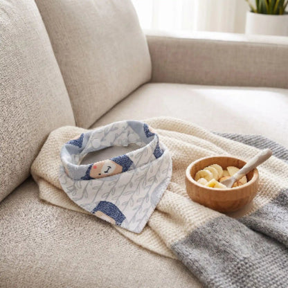 Bavoir bandana sur le sofa sur une couverture avec un bol avec banane
