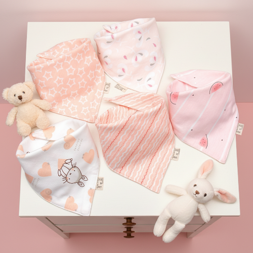 Bavoir bébé bandana couleurs variés roses sur la table de chevet de bébé