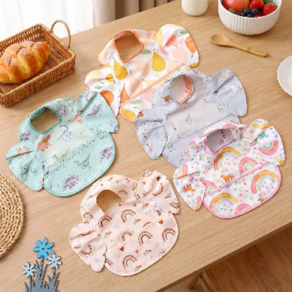 Bavoir bébé imperméable avec poche ave carc-en-ciel sur la table de cuisine