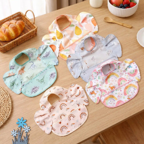 Bavoir bébé imperméable avec poche bleu sur la table en bois de cuisine 