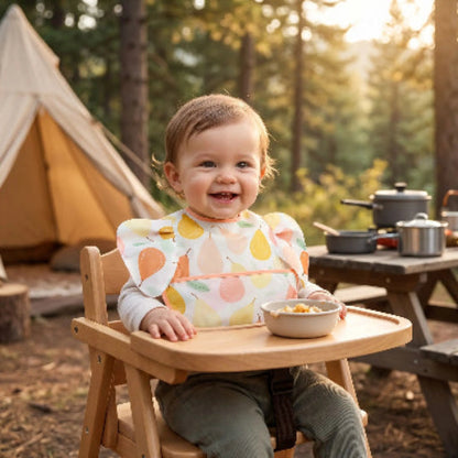 Bavoir bébé imperméable avec poche couleur orange avec bébé assis dans sa chaise haute au camping
