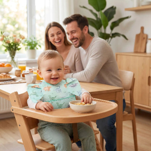 Bavoir bébé imperméable avec poche verte autour du cou de bébé assis dans sa chaise haute