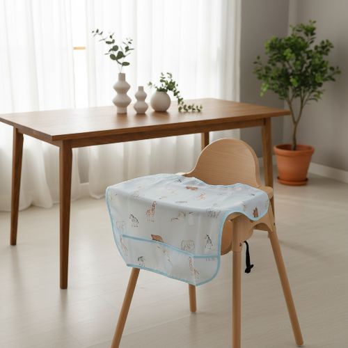Bavoir bébé imperméable bleu sur la chaise haute de bébé dans la salle a manger