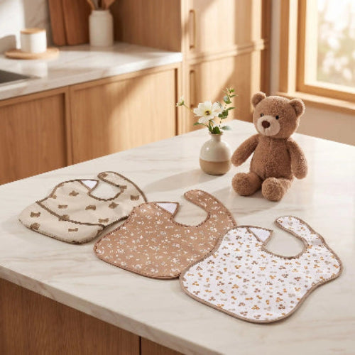 Bavoir bébé imperméable brun sur le comptoir de cuisine avec un petit ourson