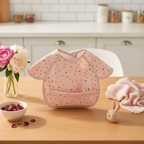 Bavoir bébé imperméable rose avec oreilles de lapin dans la poche sur le comptoir de cuisine