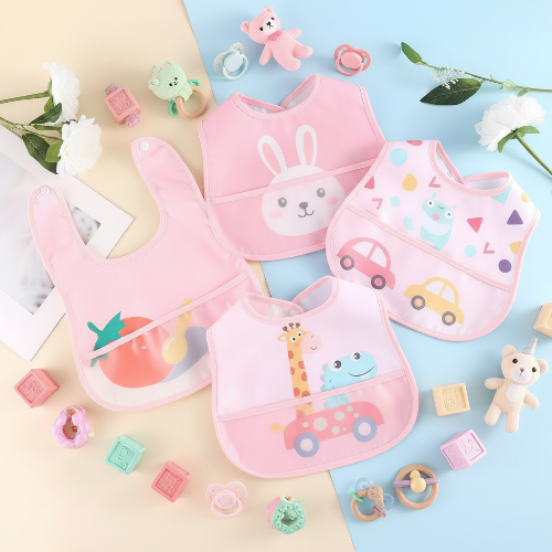 Bavoir bébé imperméable rose sur le comptoir avec jouets