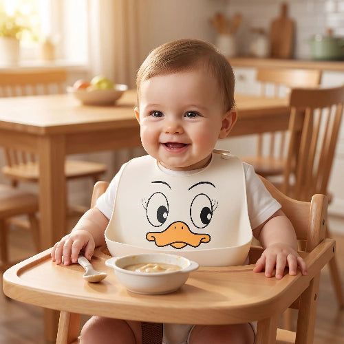 Bavoirs imperméables bébé silicone avec canard bébé assis dans sa chaise haute