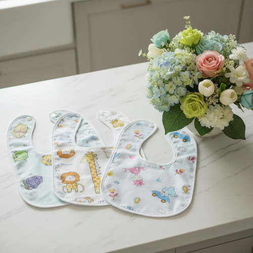 Bavoirs imperméable blancs imprimé d'animaux sur un comptoir de cuisine avec bouquet de fleurs