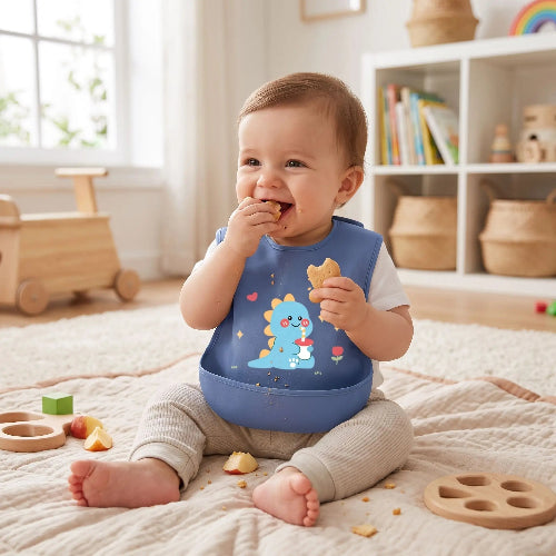 Bavoirs imperméables au cou de bébé assis dans sa salle de jeu entrain de manger une collation 