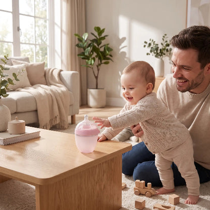 Biberon silicone anti cique 150ml rose sur la table du salon avec papa