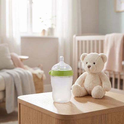 Biberon silicone anti colique 250ml vert sur table de chevet bébé et ourson