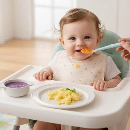 Cuillère bébé dans les mains de maman lui donne à manger