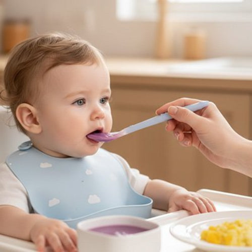 Cuillère bébé bleu pale dans les mains de maman pour lui donner à manger
