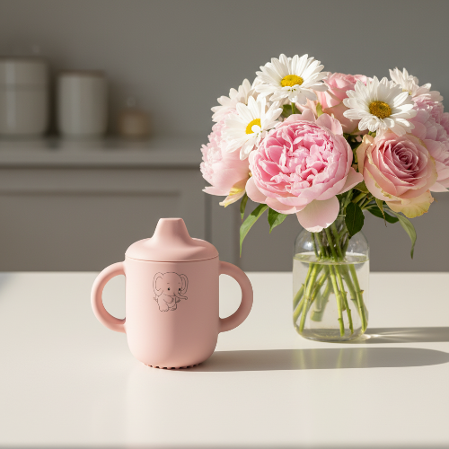 Gobelet bébé personnalisé sur le comptoir de cuisine avec bouquet de fleurs