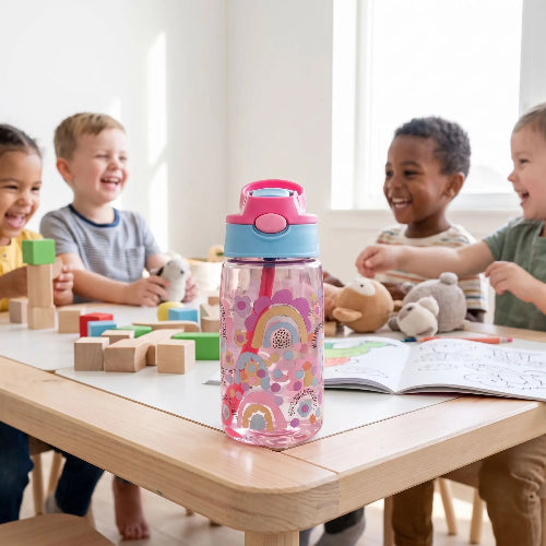 Gobelet paille bébé autonomie rose sur la table dans la salle de jeux avec les amis
