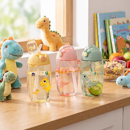Gobelet paille bébé dinosafe trois couleurs différentes sur le comptoir de cuisine