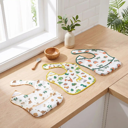 Lot de bavoir bébé avec oche différentes dinausors sur le comptoir de cuisine