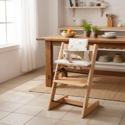 Rehausseur chaise dans la cuisine prêt de la table a diner avec bol à fruits sur la table
