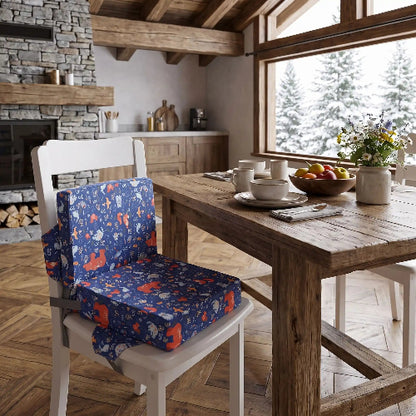 Rehausseur chaise sur la chaise de la table au chalet avec une vue par la fenêtre avec des sapins avec de la neige